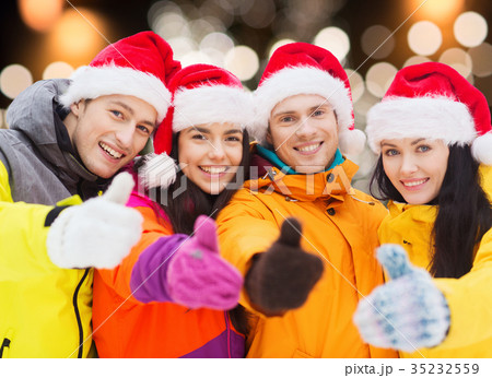 happy friends in santa hats and ski suits outdoors 35232559