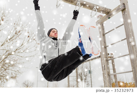 young man exercising on horizontal bar in winter 35232973