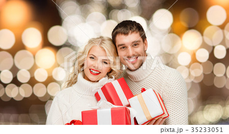 happy couple in sweaters holding christmas gifts happy couple in sweaters holding christmas gifts 35233051