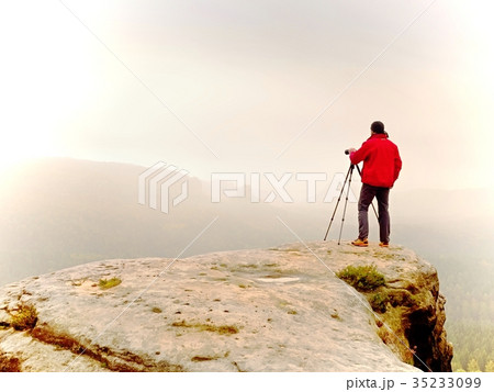 Photographr looking into viewfinder of dslr camera 35233099