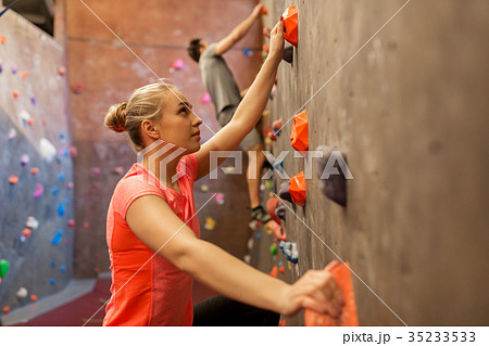 man and woman exercising at indoor climbing gym 35233533