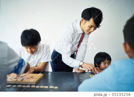 子供に将棋を教える男性 35235256