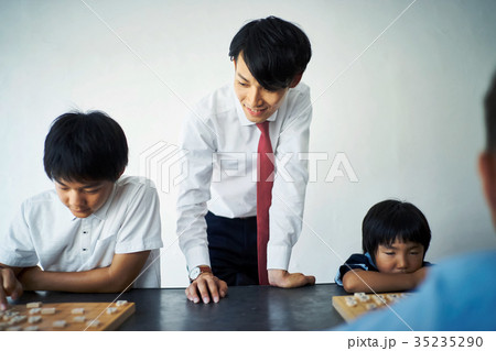 子供に将棋を教える男性 35235290