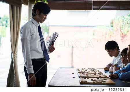 子供に将棋を教える男性 35235314