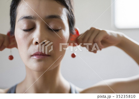 耳を引っ張る女性の写真素材