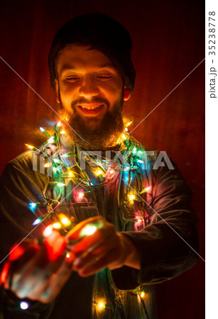 Bearded man wrapped in Christmas lights Bearded man wrapped in Christmas lights 35238778