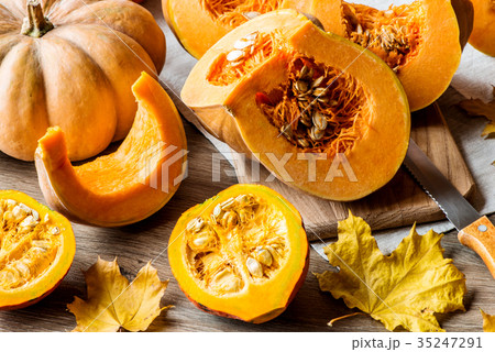 Sliced pumpkin with seeds on a wooden background Sliced pumpkin with seeds on a wooden background 35247291