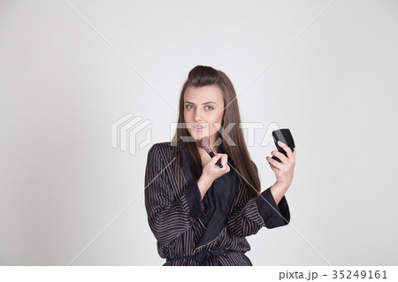 girl in coat makes brush makeup looks in the 35249161
