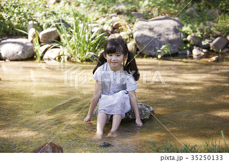 小川 水遊び 少女の写真素材