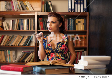 woman librarian in glasses sitting at the table 35251067