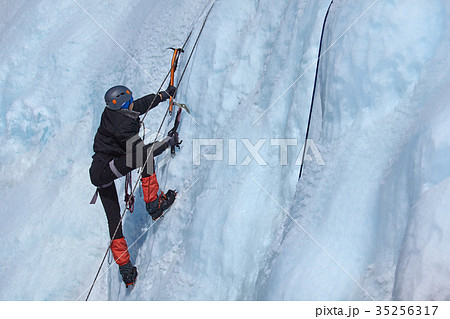 An ice climber makes his way on a frozen waterfall 35256317