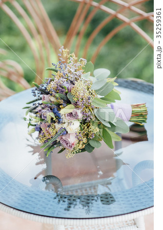 Beautiful wedding bouquet lie on glass table Beautiful wedding bouquet lie on glass table 35259361