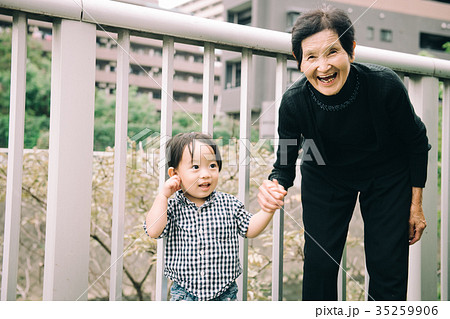 手をつなぐひ孫とひいおばあちゃん 笑顔の写真素材