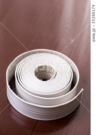 White sanitary sealant strip on the wooden table 35260174