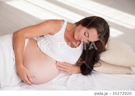 a pregnant woman is lying in bed waiting for the 35272020