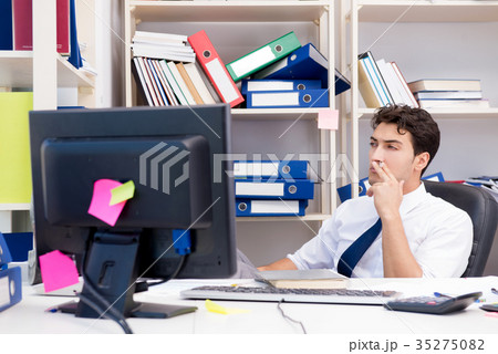 Businessman working in the office with piles of 35275082