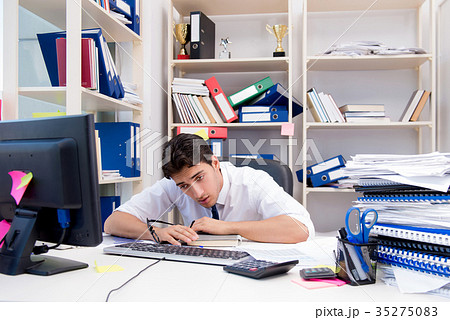 Businessman working in the office with piles of 35275083