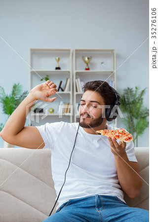 Man eating pizza having a takeaway at home Man eating pizza having a takeaway at home 35276106