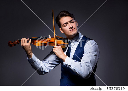 Young man playing violin in dark room Young man playing violin in dark room 35276319