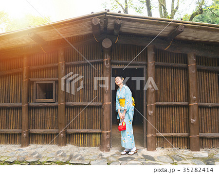 happy woman standing in front of old wooden house happy woman standing in front of old wooden house 35282414