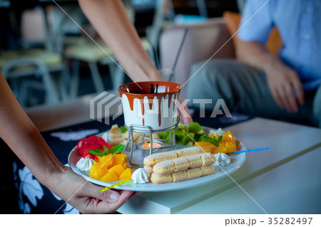chocolate fondue with fruits in blue pot 35282497