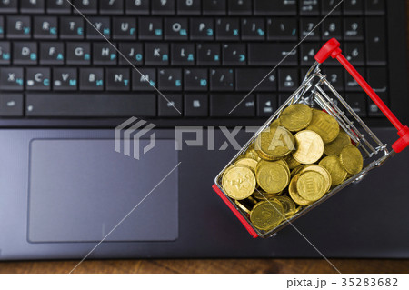 Shopping trolley with coins on a laptop 35283682