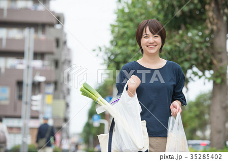 買い物する主婦 レジ袋を持つ女性の写真素材