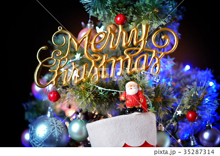 メリークリスマス クリスマスツリーとサンタクロースとプレゼント靴下とオーナメント の写真素材