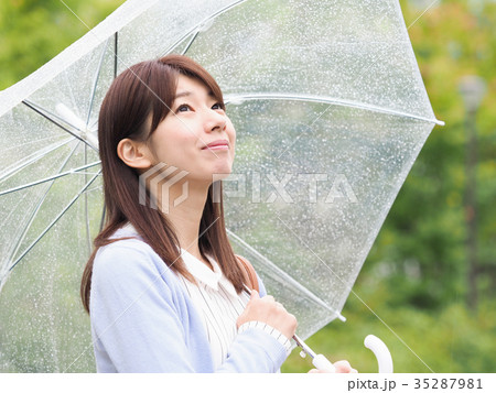 傘をさして心配そうに空を見上げる女性 傘をさして心配そうに空を見上げる女性 35287981