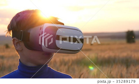 A boy stands in a wheat field at sunset in virtual 35289179