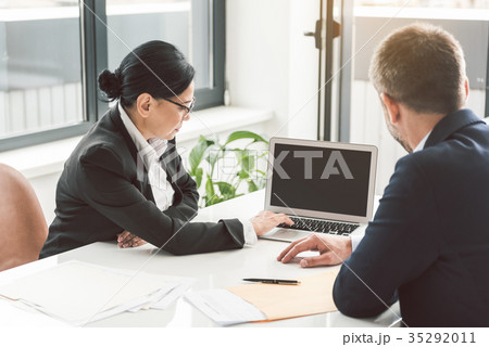 Serious woman and male watching at laptop Serious woman and male watching at laptop 35292011