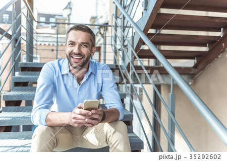 Delightful bearded guy is smiling while resting Delightful bearded guy is smiling while resting 35292602