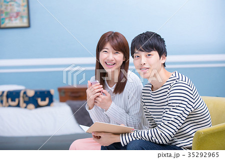 海外旅行を計画する若い男女　ノートとペン　話し合う男女　旅行計画イメージ 35292965