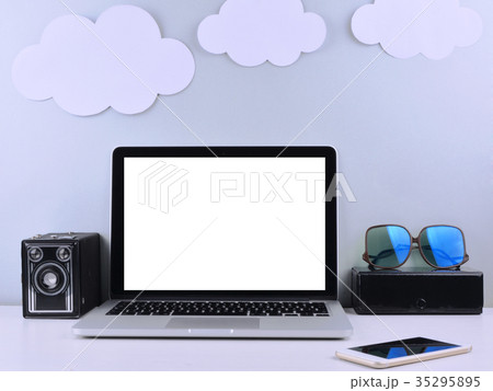 Workspace with laptop, camera, sticky notes. 35295895
