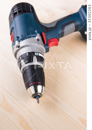 Cordless drill on the wooden board table 35302263