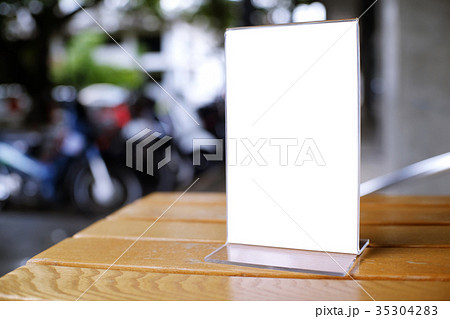 Mock up Menu frame standing on wood table in Bar Mock up Menu frame standing on wood table in Bar 35304283