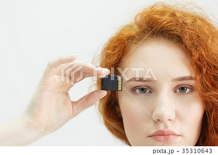 young beautiful girl holds a USB flash drive to young beautiful girl holds a USB flash drive to 35310643