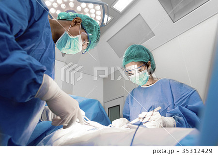 Doctors and nurse with tools in hands making surgery in operatio 35312429