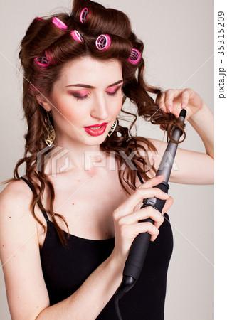 the girl with the curling Tong curler makes the girl with the curling Tong curler makes 35315209
