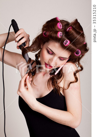 girl with hair curlers talking on the phone and girl with hair curlers talking on the phone and 35315210