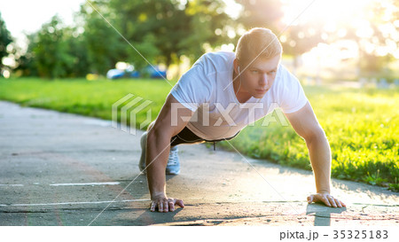 A young athletic man does push-ups. A muscular and A young athletic man does push-ups. A muscular and 35325183