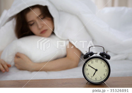 Beautiful sleeping woman lying in bed and trying 35326891