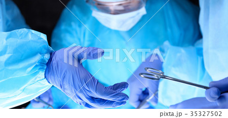 Surgeons hands holding surgical scissors and Surgeons hands holding surgical scissors and 35327502