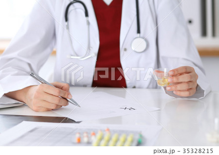 Female medicine doctor fills up  prescription for 35328215