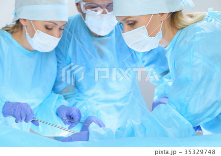 Group of surgeons at work while operating at 35329748