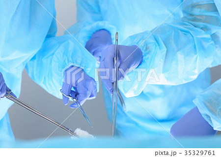 Close-up of unknown surgeons at work while Close-up of unknown surgeons at work while 35329761