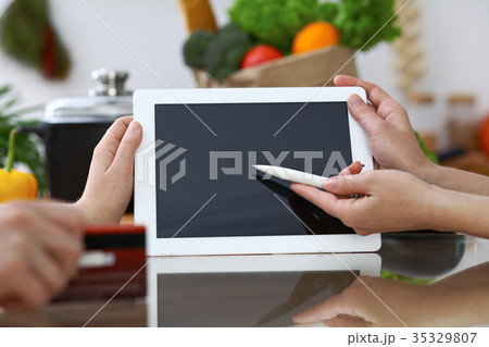 Close-up of human hands pointing into tablet  i 35329807
