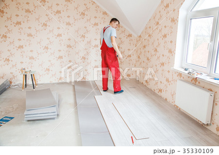 handyman laying down laminate flooring boards handyman laying down laminate flooring boards 35330109
