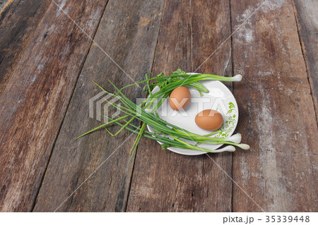 fresh chicken egg on a plate and onion in wooden fresh chicken egg on a plate and onion in wooden 35339448