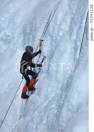 An ice climber makes his way on a frozen waterfall An ice climber makes his way on a frozen waterfall 35342138